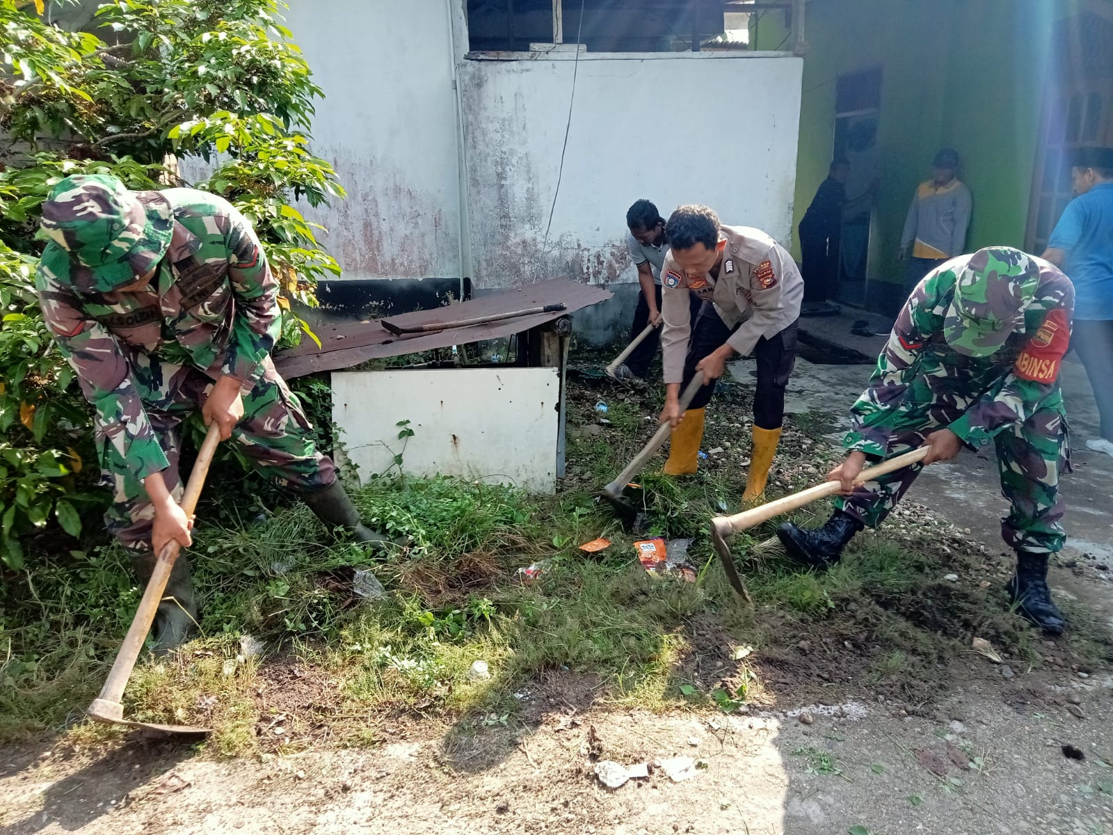 Sinergitas TNI dan Polri Lakukan Kerja Bakti Bersama di Mushola Khusnul khotimah Desa Kampung Baru T